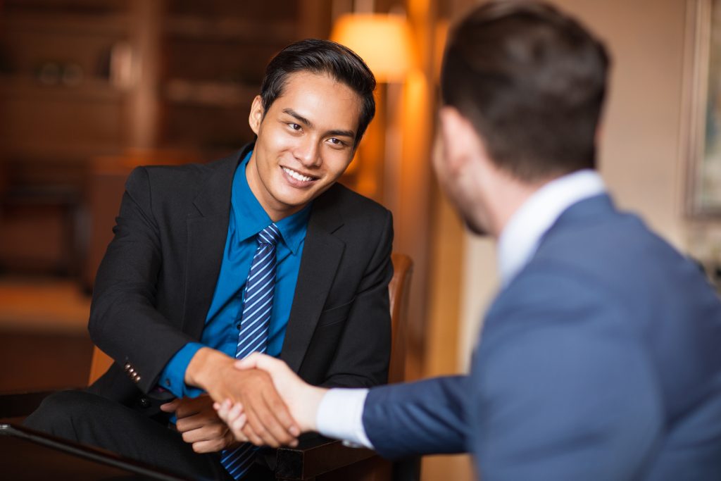 Smiling executive shaking hands, demonstrating effective business networking in leadership