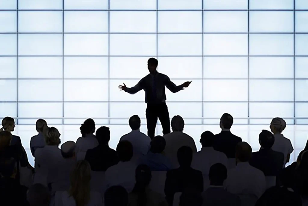 Seorang pemimpin memberikan pembentangan di hadapan audiens sambil membincangkan strategi gaya kepimpinan berkesan dalam organisasi.