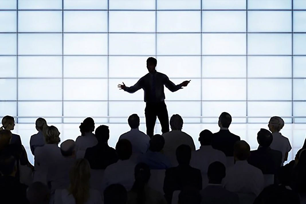 Seorang pemimpin memberikan pembentangan di hadapan audiens sambil membincangkan strategi gaya kepimpinan berkesan dalam organisasi.