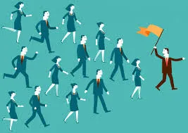 Ilustrasi grafik menunjukkan seorang pemimpin lelaki di hadapan memegang bendera oren dan menunjuk arah, diikuti oleh sekumpulan ahli pasukan lelaki dan wanita yang berlari ke arah yang sama, melambangkan kepimpinan yang berwibawa dan berorientasikan matlamat.